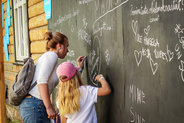 Opinion festival attendees write on a blackboard